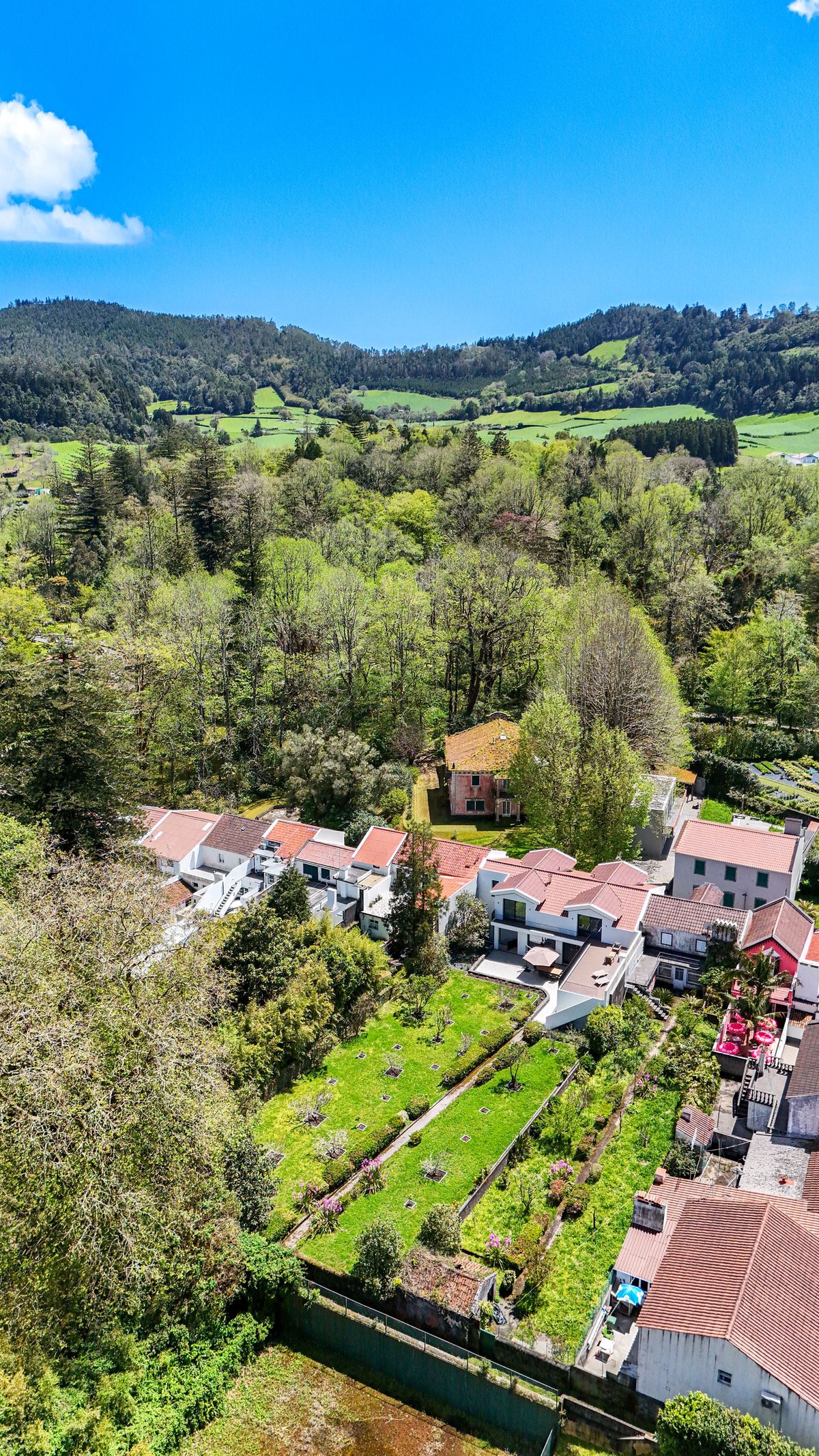 Vista aérea de drone da Casa da Bruma, telhado branco no vale