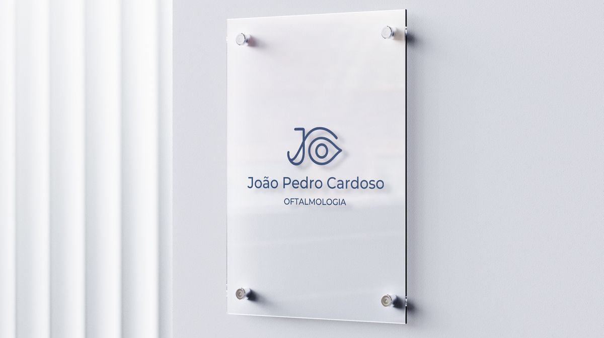 Placa de vidro com o logotipo do Dr. João Pedro Cardoso na entrada do consultório